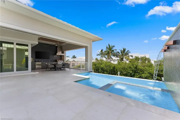 View of swimming pool with a patio area, a pool with connected hot tub, and outdoor dining area