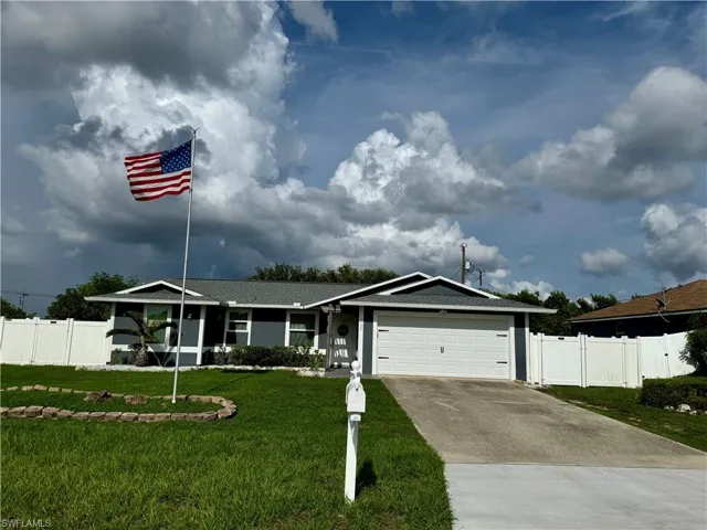 Single story home featuring concrete driveway and a garage