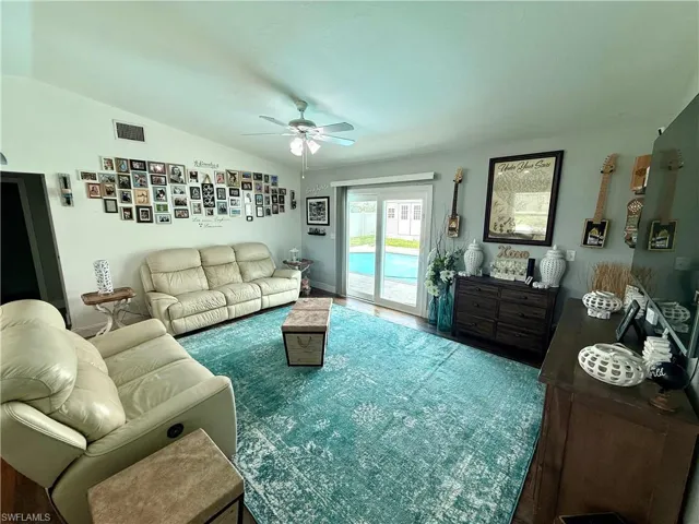 Living room featuring ceiling fan and lofted ceiling