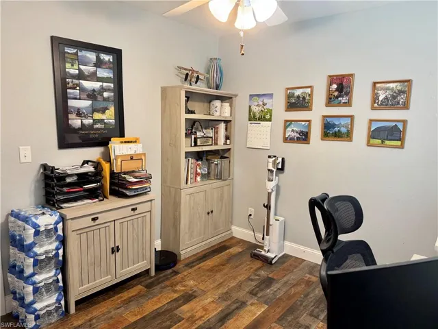 Office area featuring a ceiling fan and dark wood-type flooring