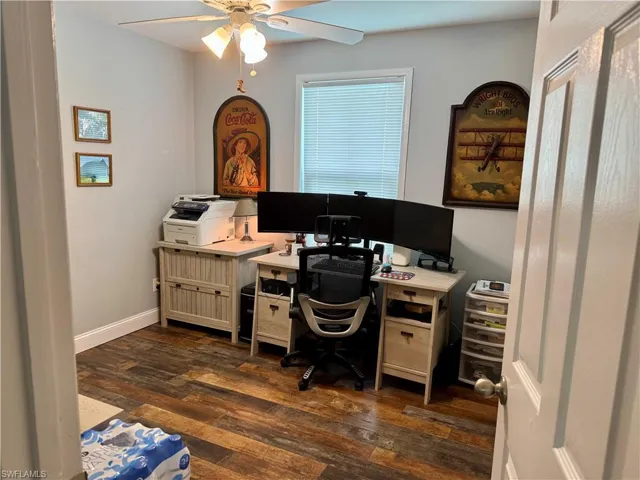 Home office featuring ceiling fan and dark wood finished floors