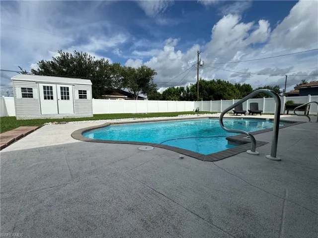 View of pool with a patio area and an outbuilding