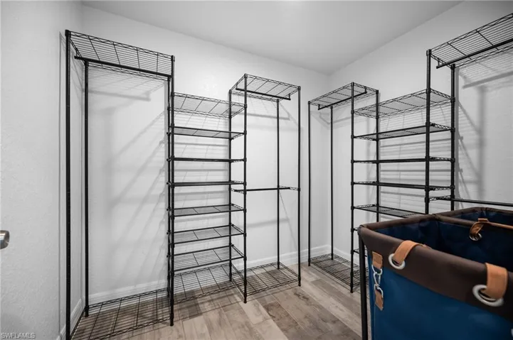 Customizable wire shelving system with hanging rods and wood-finish flooring