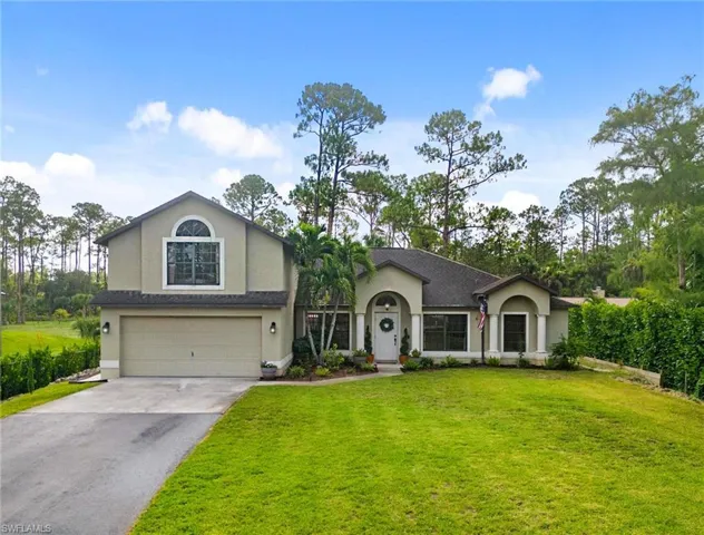 View of front facade featuring a front yard and a garage