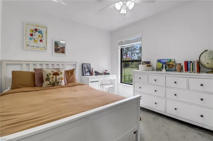 Carpeted bedroom featuring ceiling fan