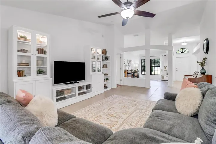 Tiled living room featuring a high ceiling and ceiling fan