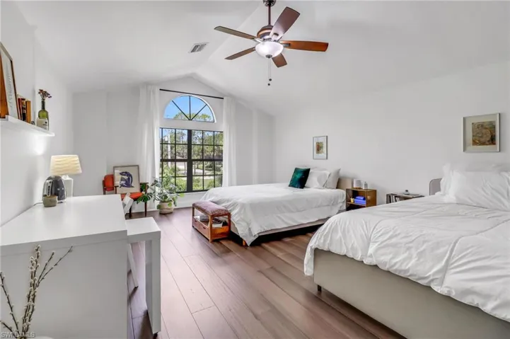 Bedroom with vaulted ceiling, hardwood / wood-style flooring, and ceiling fan