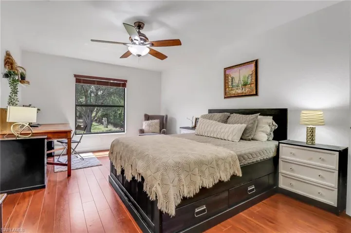 Bedroom with ceiling fan and hardwood / wood-style floors
