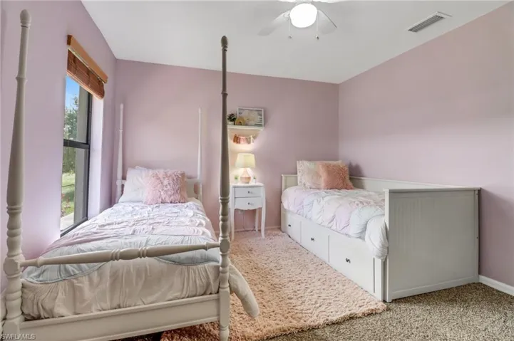 Carpeted bedroom featuring ceiling fan