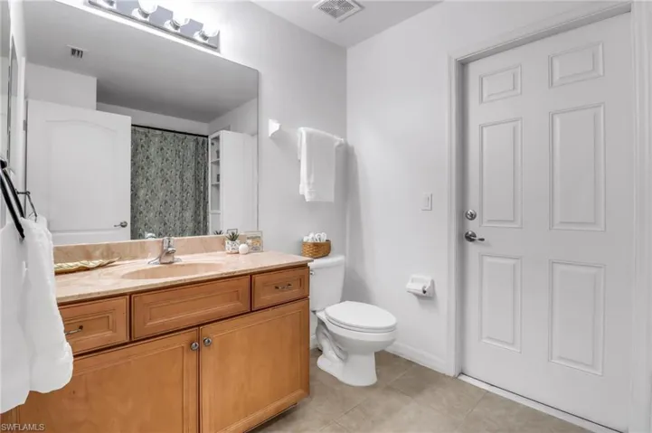 Bathroom featuring vanity, tile patterned flooring, toilet, and a shower with curtain