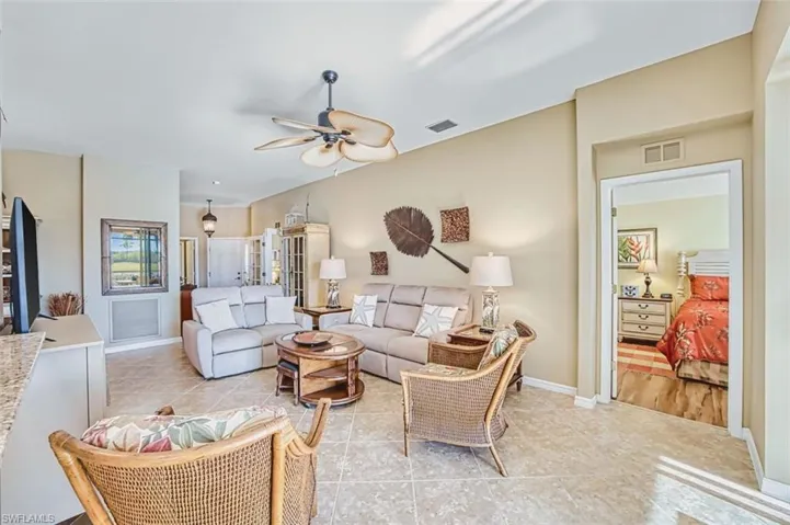 Living room with ceiling fan and light tile patterned floors