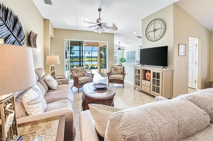 Living room with vaulted ceiling, tile patterned floors, and recessed lighting