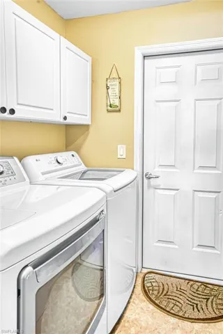 Laundry room featuring separate washer and dryer and cabinet space