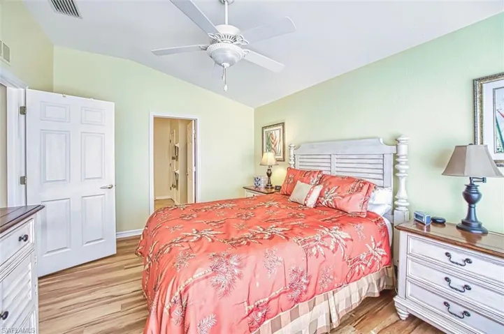 Bedroom with vaulted ceiling, light wood-type flooring, and ceiling fan