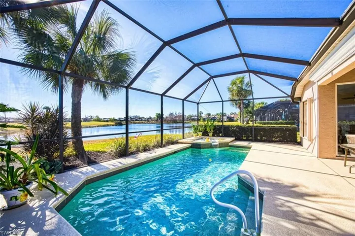 Combined pool / hot tub with a sunroom, a water view, a lanai, and a patio area