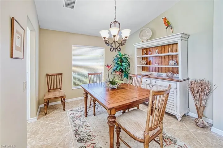 Dining space featuring vaulted ceiling, suspended lighting, and light tile patterned floors