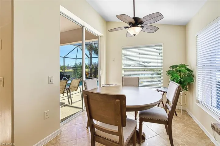 Dining room with a sunroom, light tile patterned floors, plenty of natural light, and a ceiling fan
