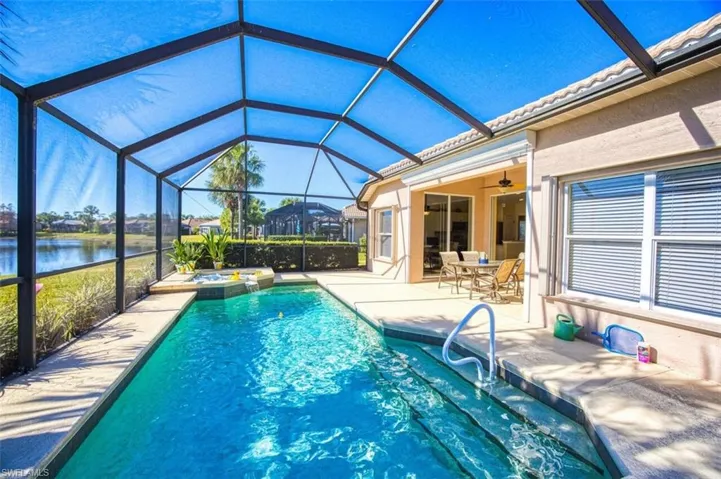 Outdoor pool with a lanai, a jacuzzi, outdoor dining space, a sunroom, and a patio area