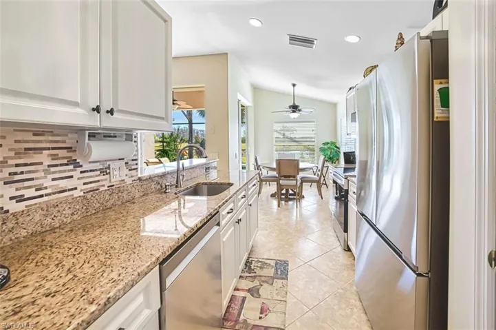 Kitchen featuring stainless steel appliances, white cabinets, light stone counters, recessed lighting, and light tile patterned flooring