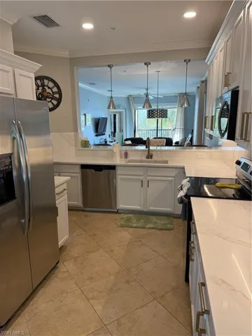 Kitchen with white cabinetry, refrigerator, stove, ornamental molding, and dishwasher