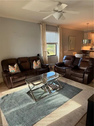 Tiled living room with crown molding and a ceiling fan