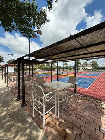 View of patio featuring a tennis court and a pergola