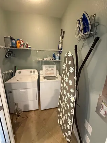 Laundry area with washing machine and dryer and tile patterned floors