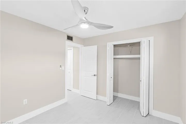 Unfurnished bedroom with a ceiling fan and a closet