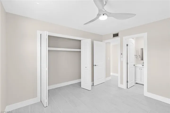 Unfurnished bedroom with a ceiling fan, a closet, and connected bathroom
