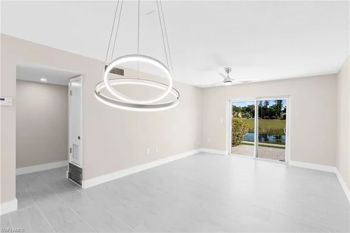 Spare room with a chandelier, ceiling fan, and a water view