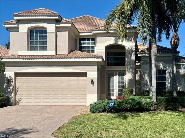 Mediterranean / spanish-style house featuring driveway, stucco siding, a garage, and a front lawn
