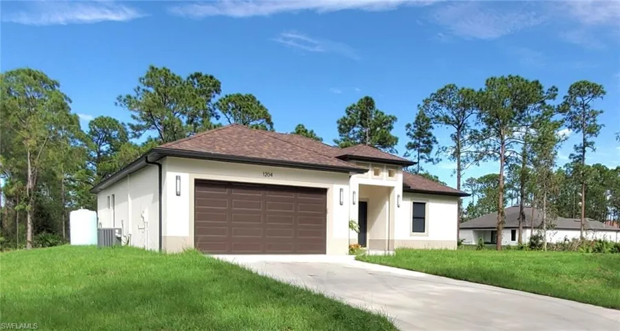 View of front of home featuring a garage and a front yard