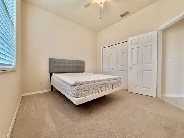 Bedroom featuring light colored carpet, a closet, and ceiling fan