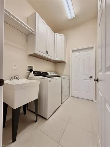 Laundry area featuring cabinet space, Wash Basin, washer and dryer