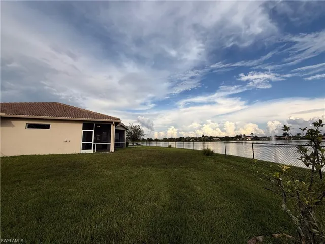 Fenced backyard with a sunroom and a water view