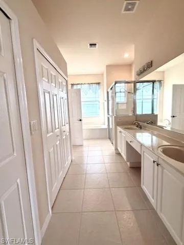 Primary Bathroom with double vanity, a shower stall, bath and private head
