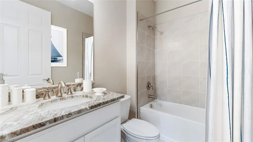 Full bathroom with vanity, shower / tub combo, and toilet