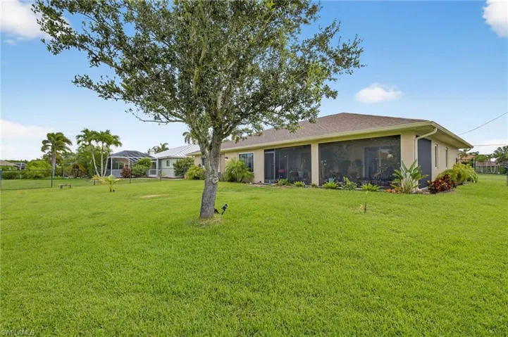 Rear view of property featuring a sunroom and stucco siding