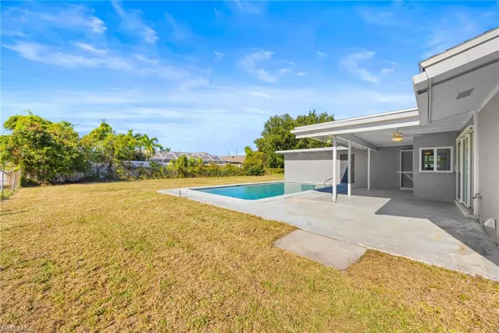 Swimming pool featuring a lawn and a patio