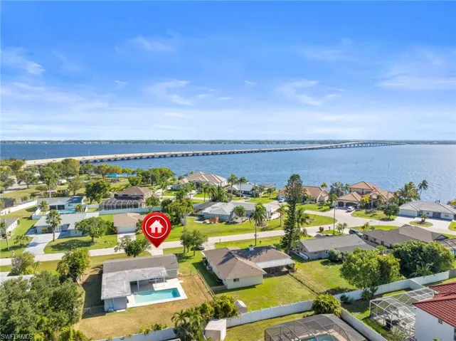 Aerial perspective of suburban area featuring a notable bridge and a large body of water
