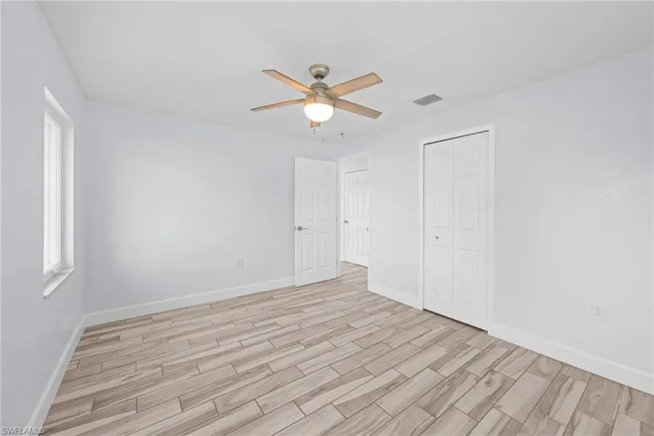 Unfurnished bedroom with wood finish floors, a ceiling fan, and a closet