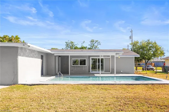 Rear view of property featuring a patio, an outdoor pool, and stucco siding