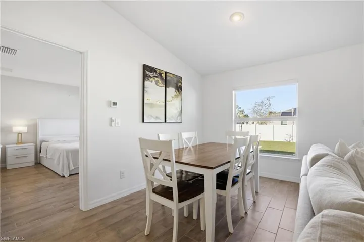 Dining area with light wood-style flooring and vaulted ceiling