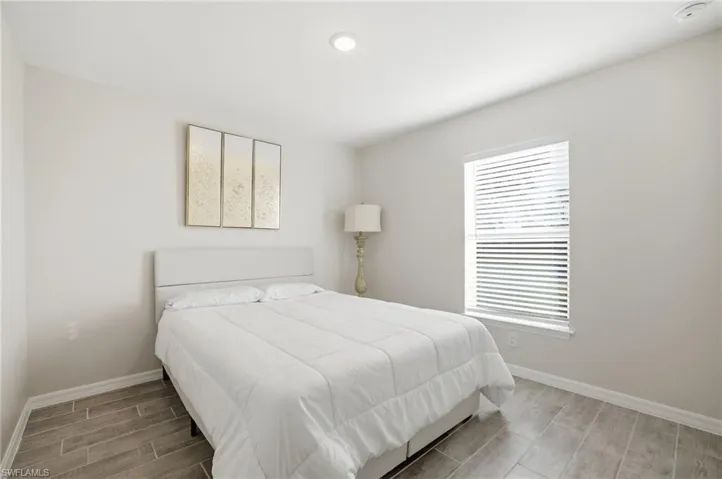 Bedroom featuring wood tiled floors and baseboards