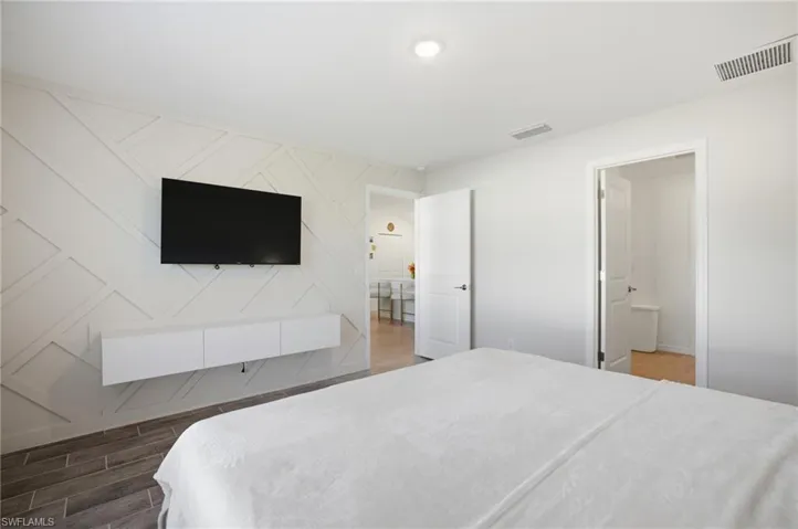 Bedroom with wood tiled floors and an accent wall