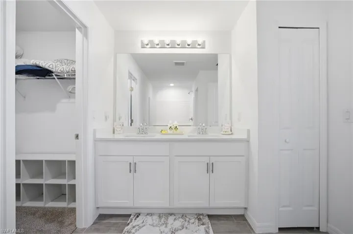 Full bath with a walk in closet and double vanity