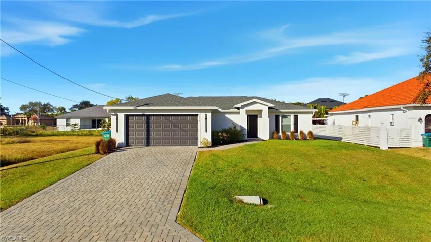Ranch-style house featuring decorative driveway, a garage, stucco siding, and roof with shingles