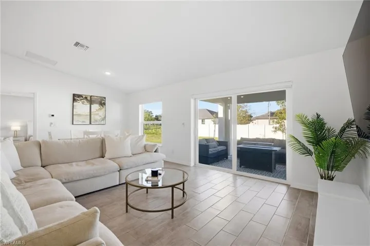 Living room featuring vaulted ceiling, wood tiled floors, and recessed lighting