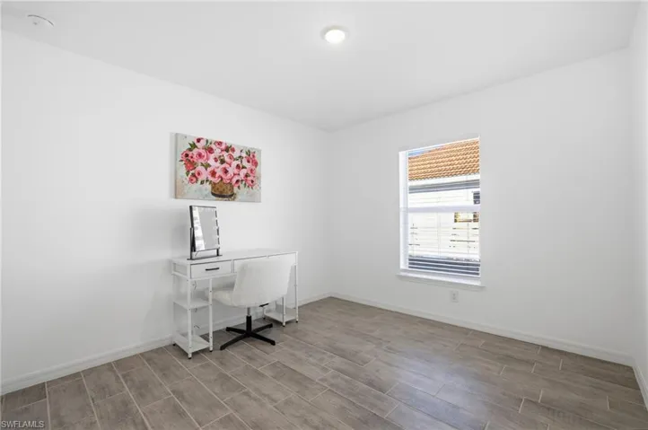 Office space with baseboards and wood tiled floors