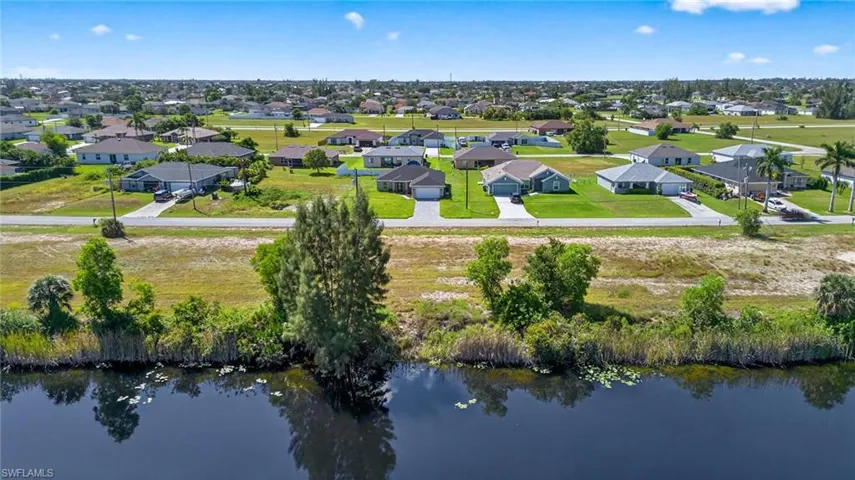 Aerial view of residential area featuring a nearby body of water